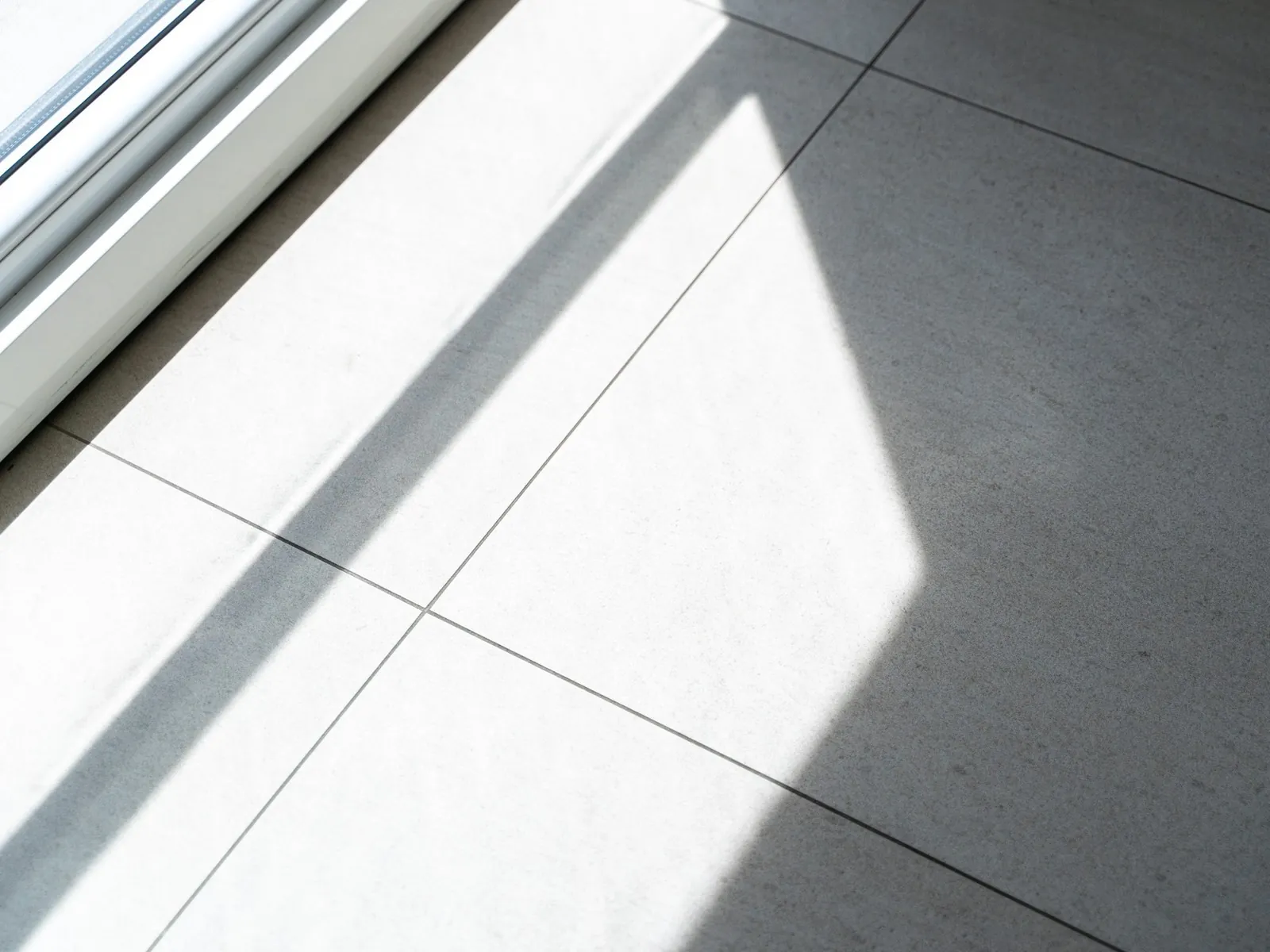Sol de grands carreaux de pierre gris pâle et ombre portée nette